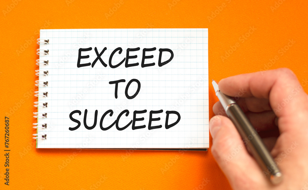 Exceed to succeed symbol. Concept words Exceed to succeed on beautiful white note. Beautiful orange background. Businessman hand. Business and exceed to succeed concept. Copy space.