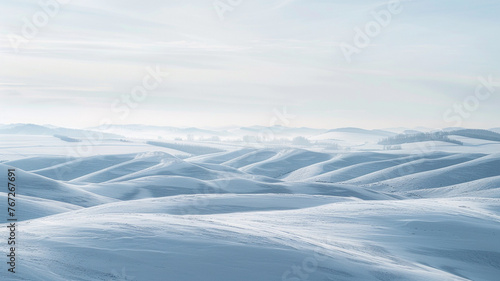 A panoramic view of rolling hills covered in fresh snow, the details of the hills crisp against a softly blurred, clear winter sky. The expansive, \
