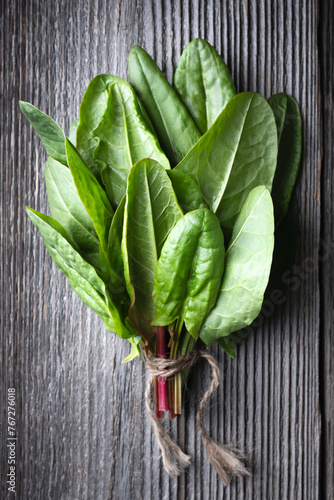Bunch of fresh organic sorrel leaves on wooden table close up. Food photography