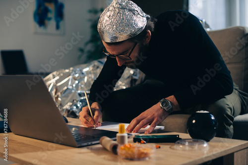 A man in a tinfoil hat is engaged in conspiracy theory.