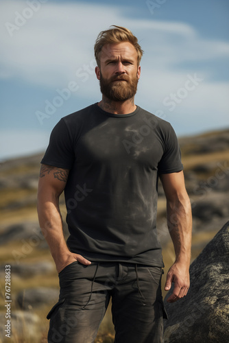 Male model posing outdoors with plain blank black canvas t-shirt mockup