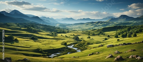 Idyllic landscape with green grass covered morning mountains © KRIS