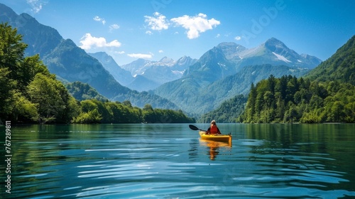 Person Kayaking on Lake Surrounded by Mountains