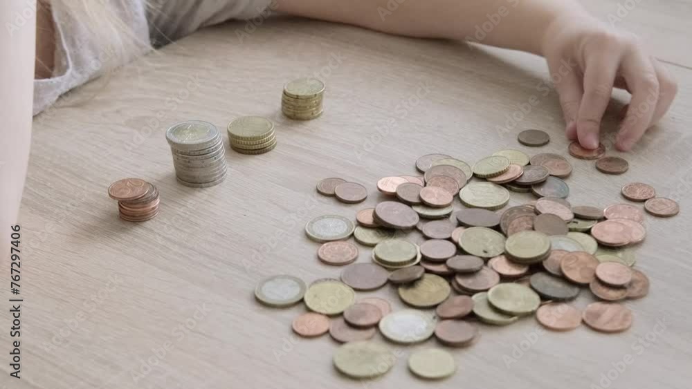 Close-up young hands organizing euro coins into stacks, budgeting skills in children concept, playful activities to introduce children to basic financial concepts, spending money Close-up young hands organizing euro coins into stacks, budgeting skills in children concept, playful activities to introduce children to basic financial concepts, spending money