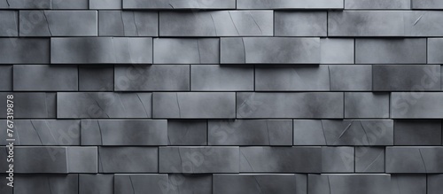 A close up of a rectangular grey brick wall showcasing the intricate brickwork pattern and various tints and shades of grey in the composite material