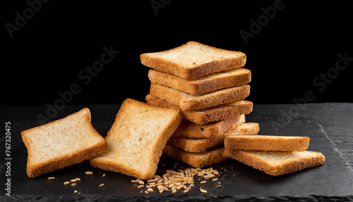 Close-up of square bread rusks pile whole wheat toast slices. Black background. photo