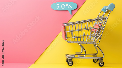 Empty shopping cart on pink and yellow background fifty percent discount
