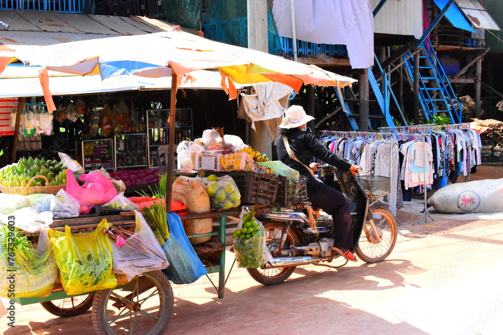 Fototapeta premium SIEM REAP, CAMBODIA - April 22, 2023: Unidentified Khmer woman selling fish at food marketplace on April 22, 2023 in Siem Reap, Cambodia. Street food markets is popular tradition in asia