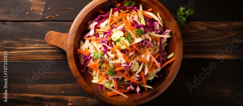 A wooden bowl filled with coleslaw, a comforting side dish made from a mixture of ingredients like cabbage and carrots, sits on a wooden table