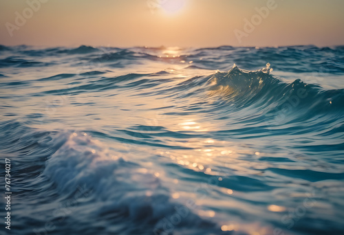 Close-up of ocean waves with sunlight reflecting on water at sunset. © Tetlak