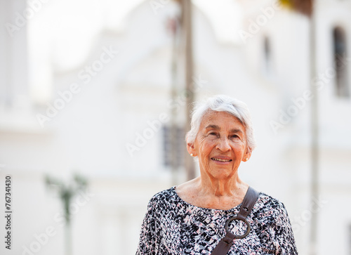 Senior adult woman at the central square in the city of Guaduas located in the Department of Cundinamarca in Colombia. Senior lifestyle. Senior travel concept.