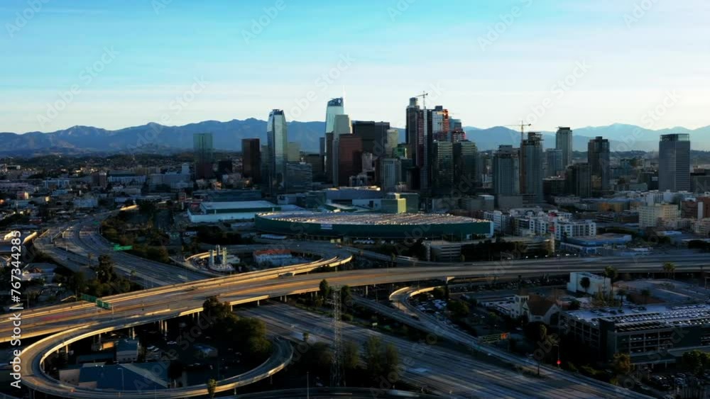Aerial Panning Time Lapse Shot Of Cars Moving On Bridge Roads In Modern Residential City By Mountains Against Clear Sky During Sunset - Los Angeles, California Aerial Panning Time Lapse Shot Of Cars Moving On Bridge Roads In Modern Residential City By Mountains Against Clear Sky During Sunset - Los Angeles, California