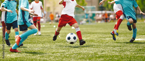 Young Players in Soccer Game. Boy Kicking Soccer Ball Towards Goal. School Boys Playing a Soccer Football Match. Kids Kicking the Ball During Junior Soccer League © matimix