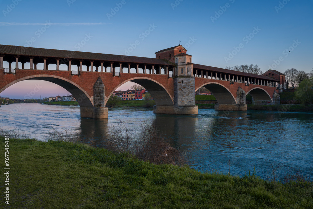 Nice view of Ponte Coperto (covered bridge) is a bridge over the Ticino river in Pavia at sunset, Lombardy, Pavia, Italy