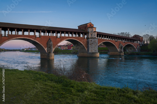 Nice view of Ponte Coperto (covered bridge) is a bridge over the Ticino river in Pavia at sunset, Lombardy, Pavia, Italy