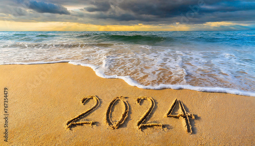 2024 written on the sand on the beach and sea wave background. New year, 2024 vacation season