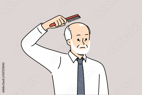 Elderly balding man holds comb over head, upset about hair loss due to old age. Balding businessman in white shirt and tie is thinking of hair transplant operation on forehead and occiput
