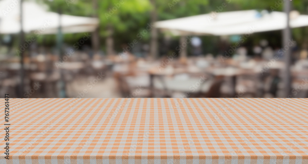 empty gingham pattern table top with blurry outdoor restaurant or cafe background, blank counter for product montage advertising
