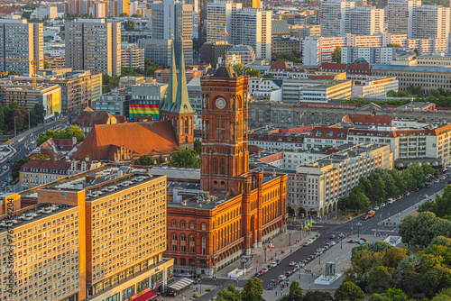 Red Town Hall of Berlin in the center of the capital of Germany. Residential and commercial buildings along the street. View from above of the skyline in sunshine. Church in the background photo