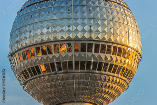 Detail of the sphere from the television tower in Berlin. Part of the tallest building in the capital of Germany with reflections on the window panes of the glass front in the evening in the sunshine