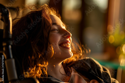 A close-up image of a beautiful girl in a wheelchair, her face illuminated by the warm light as she shares a laugh with friends
