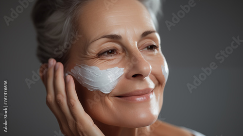 Graceful Aging: Mature Woman with Moisturizing Cream on Face
