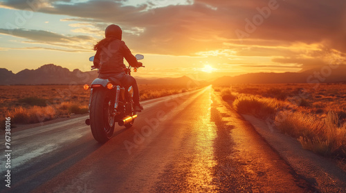 Amidst a desert landscape bathed in golden light, a biker cruises along a remote highway, the vast expanse stretching out before them like an endless sea of possibility. With each