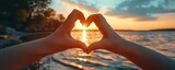  Close-up of a kid s hands forming a heart shape around a summer sunset love of vacation