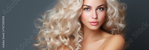 Beautiful woman with radiant long blonde hair, ideal for hair care. Gray background with copy space