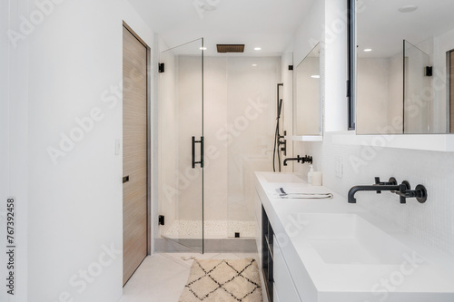 a white bathroom with large glass doors and sink area with wood paneling