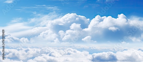 A plane is flying high in the sky surrounded by billowy clouds photo