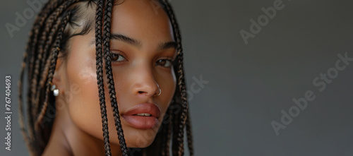 A woman with dreadlocks and a nose ring. She has a smile on her face