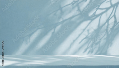 Blurred shadow from palm leaves on the light blue wall. Minimal abstract background for product presentation. Spring and summer. 