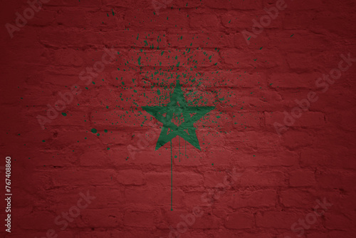 colorful painted big national flag of morocco on a massive brick wall