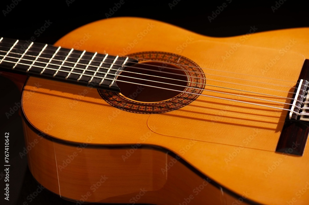 Classical Spanish flamenco guitar close up, dramatically lit isolated on black background with copy space. Classical Spanish flamenco guitar close up, dramatically lit isolated on black background with copy space.