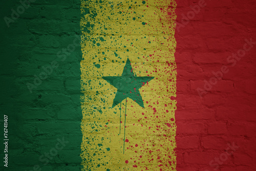 colorful painted big national flag of senegal on a massive brick wall