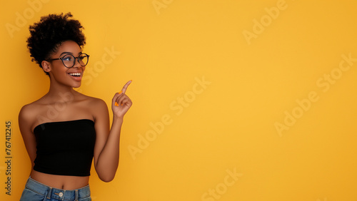 A young and beautiful african american black girl, hand pointing to her side, on yellow background, youtube 4k video thumbnail format photo