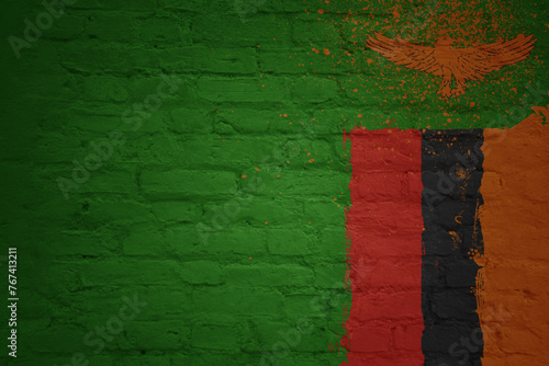 colorful painted big national flag of zambia on a massive brick wall
