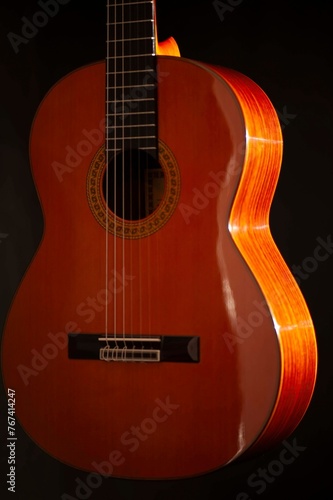 Classical Spanish flamenco guitar close up, dramatically lit isolated on black background with copy space.