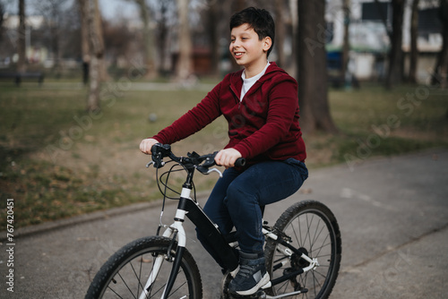 Smiling young boy riding his bicycle through a park, experiencing the joy of childhood and the freedom of outdoor activities.