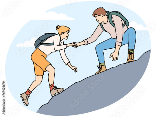 Man help female friend hiking