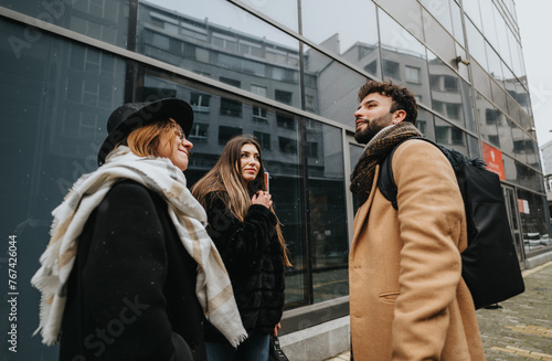 Young business teammates collaboration in snowy urban environment.