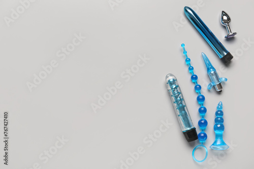 Different blue sex toys on grey background