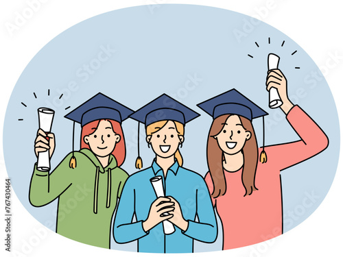 Happy girls holding graduation diplomas