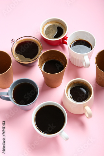 Many cups of hot coffee on pink background