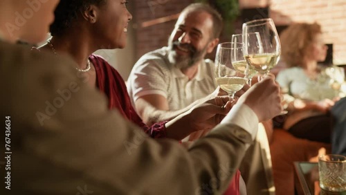 Group of friends laughing and enjoying wine together at a cozy home party