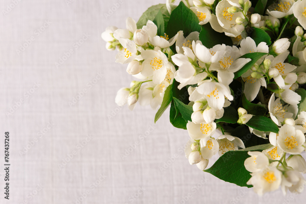 Bouquet of fresh delicate spring jasmine flowers on a linen tablecloth on the table. Top view, empty space. Bouquet of fresh delicate spring jasmine flowers on a linen tablecloth on the table. Top view, empty space.