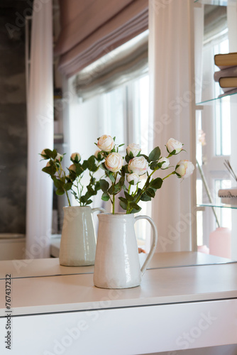 Bouquet of flowers in a vase in front of a mirror in the bedroom. Interior details. 