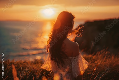 A woman standing in a field with the sun setting in the background