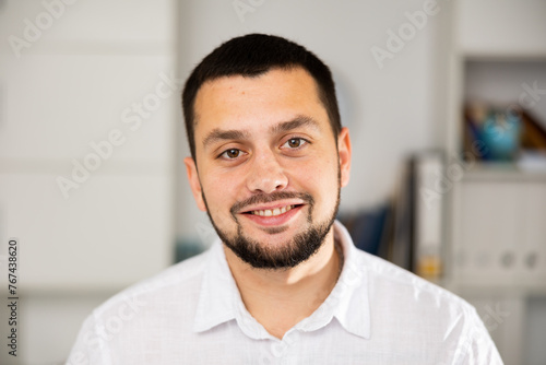 Portrait of positive caucasian man office worker smiling and looking at camera.